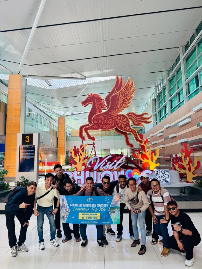 A group of travellers together in a terminal with a red-and-gold winged horse decoration.
