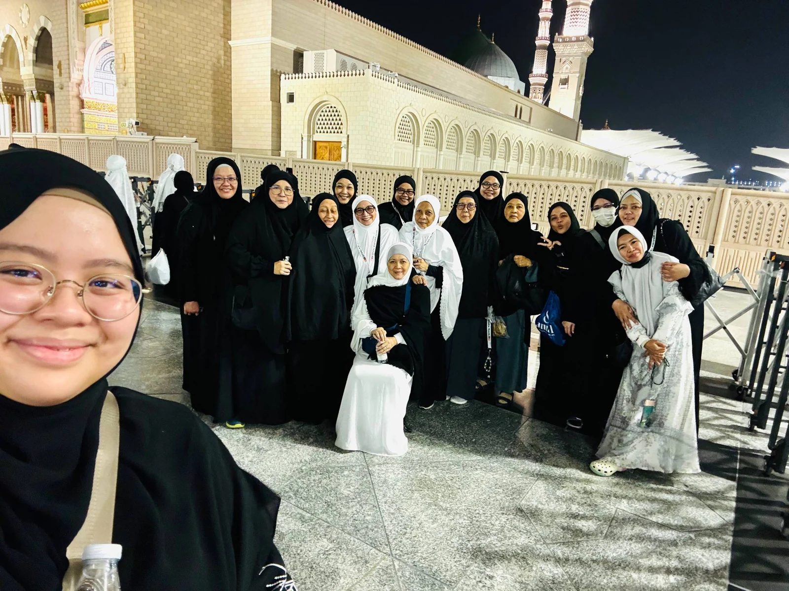 Swafoto peserta bersama kumpulan jemaah di halaman masjid pada waktu malam.