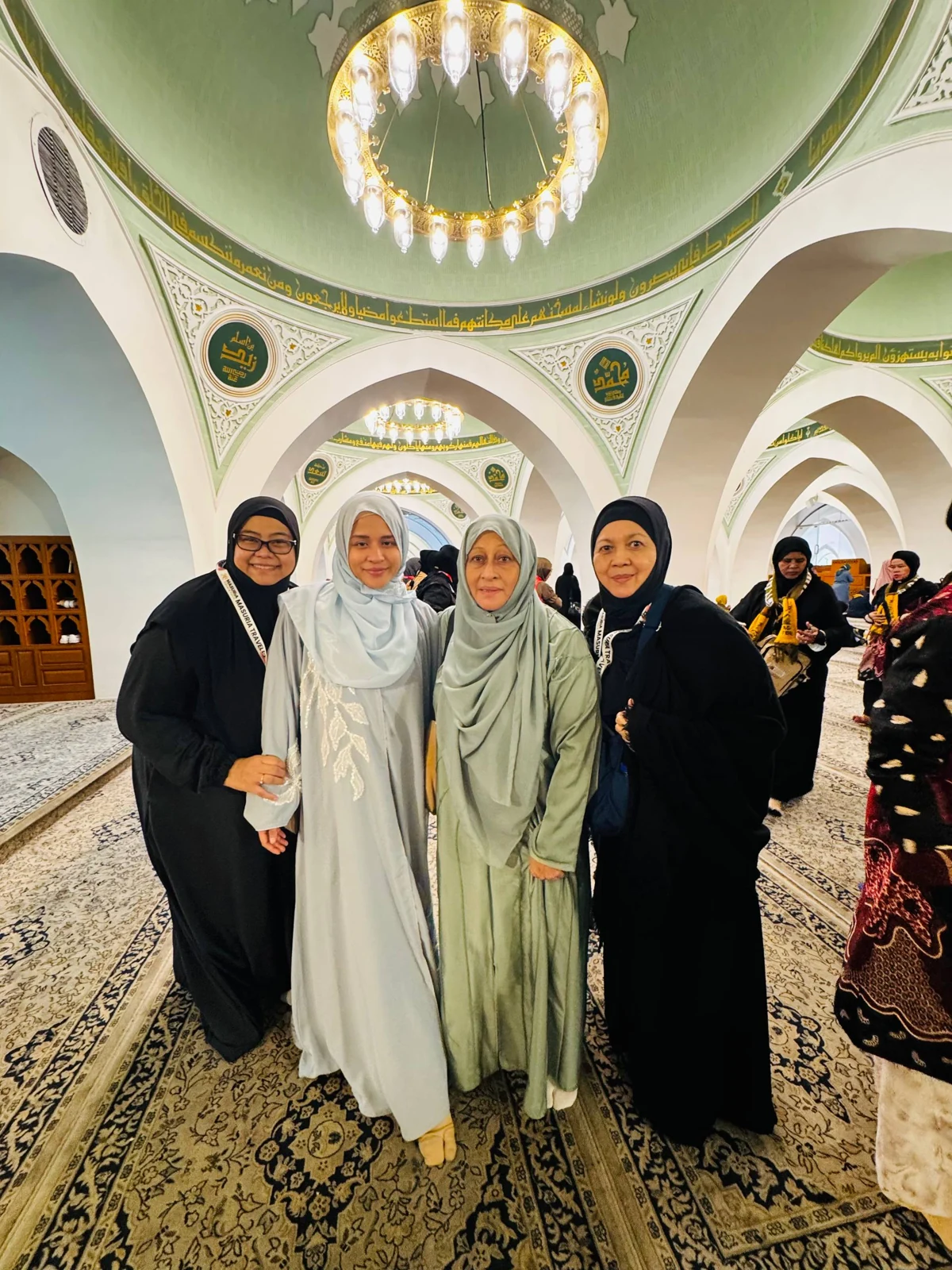 Empat jemaah bergambar di bawah siling dan gerbang masjid yang dihias indah.