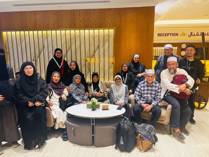 A group of travellers gathers in the hotel reception area.